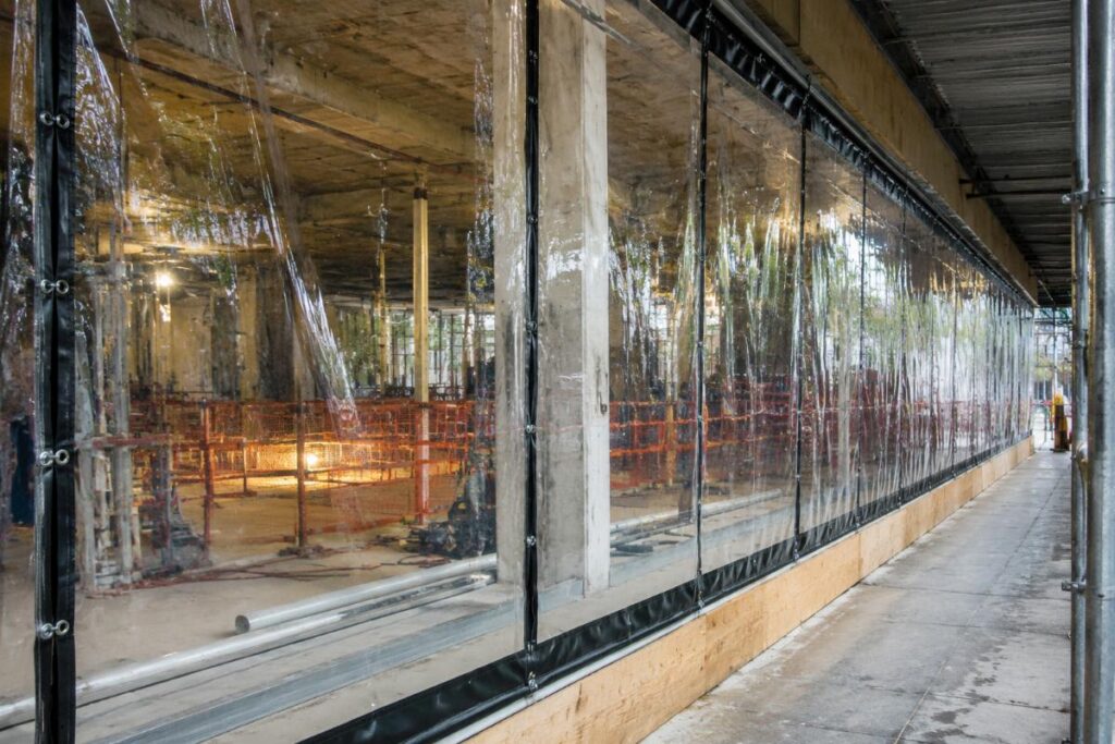 Clear transparent PVC tarpaulin installed as temporary construction enclosure windows