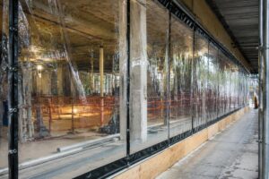 Clear transparent PVC tarpaulin installed as temporary construction enclosure windows