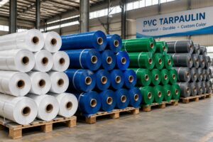 Custom color PVC tarpaulin rolls stacked in factory warehouse (white, blue, green, grey variants)
